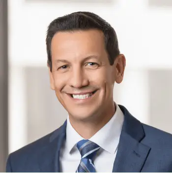 Smiling businessman in a blue suit and striped tie portrait.