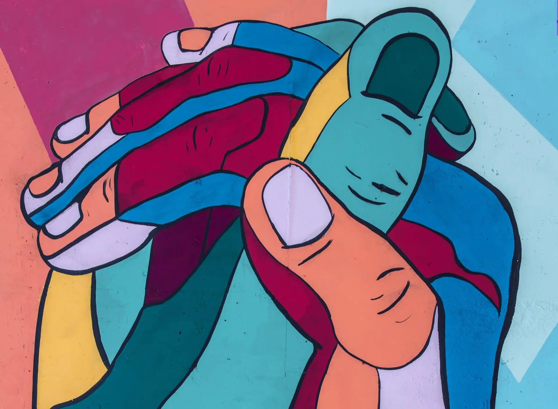 Vibrant mural with oversized, interwoven hands depicted in bold color blocks