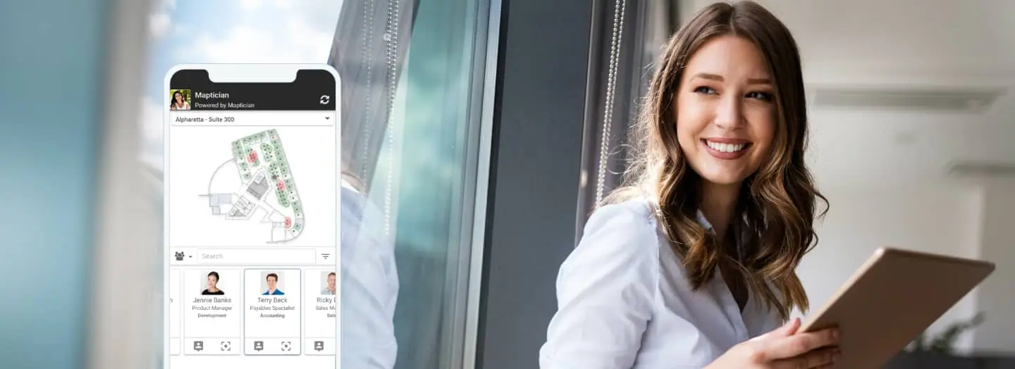 Smartphone displays floor plan; woman views it; office setting.