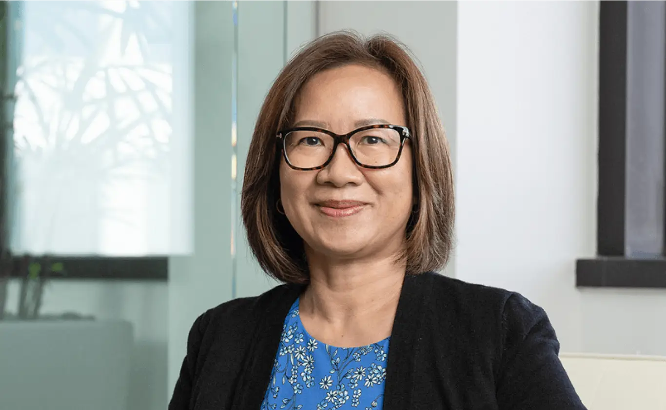 Professional woman with short brown hair and glasses in a bright office setting