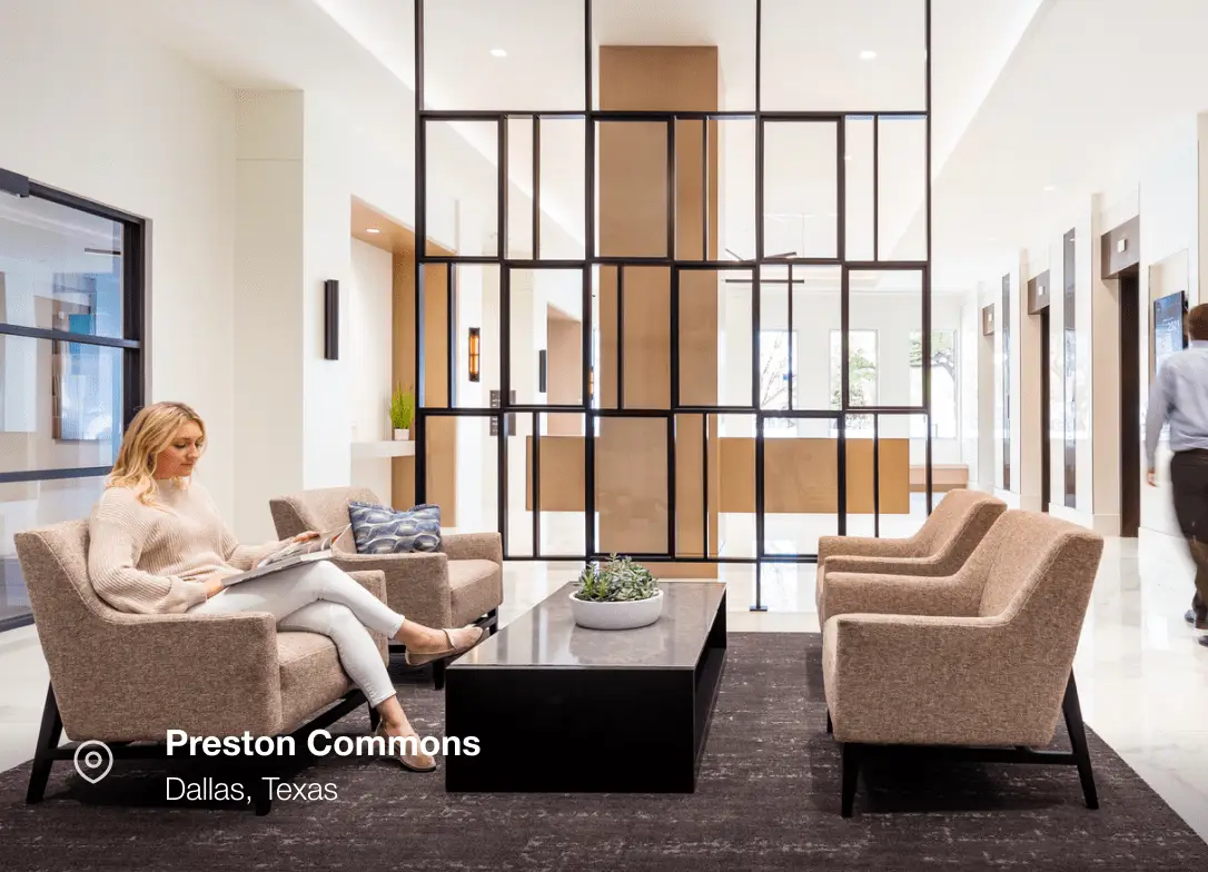 Woman sits reading in modern lobby; Preston Commons, Dallas, Texas.