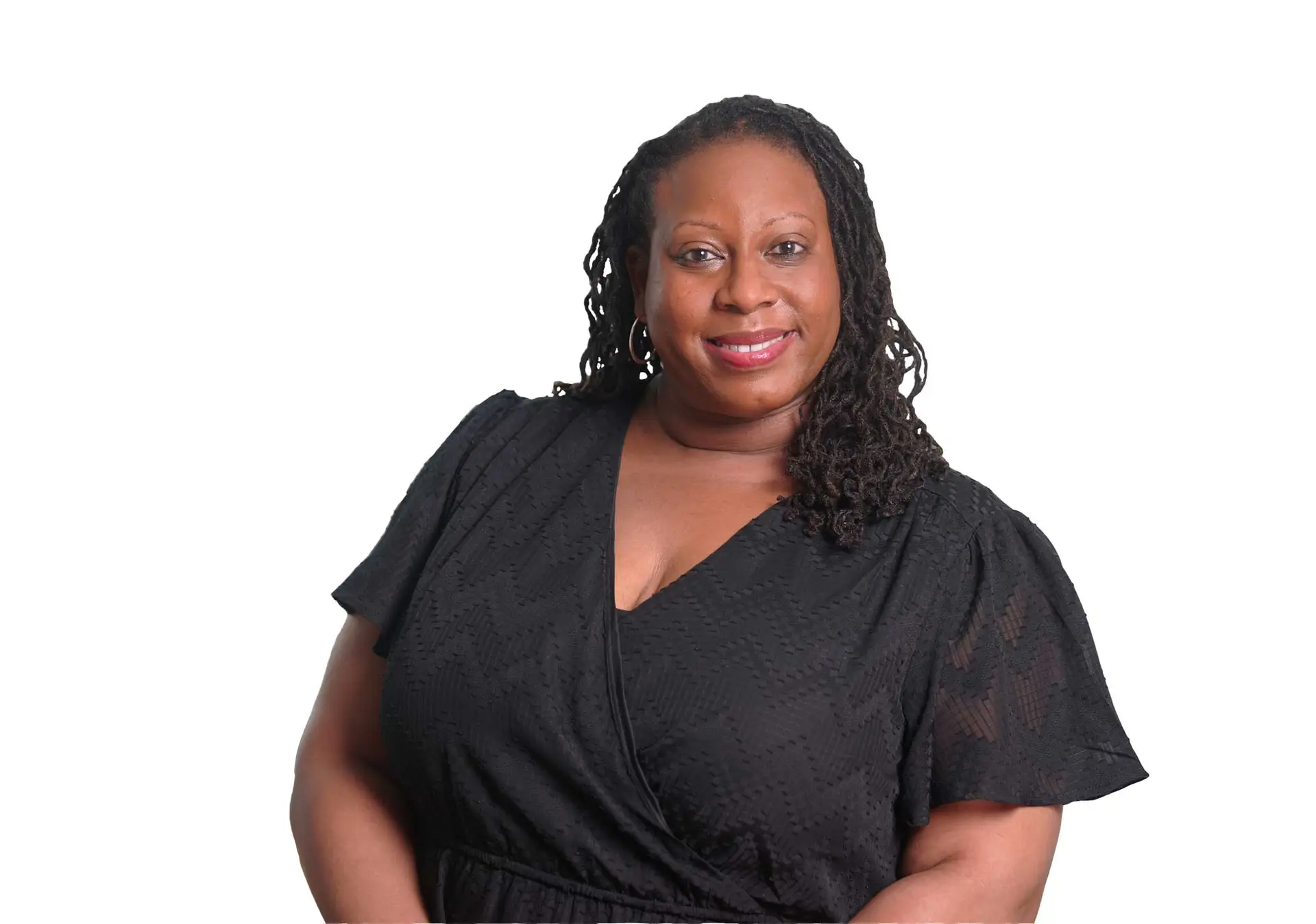 Smiling woman wearing a black patterned blouse against a white background.
