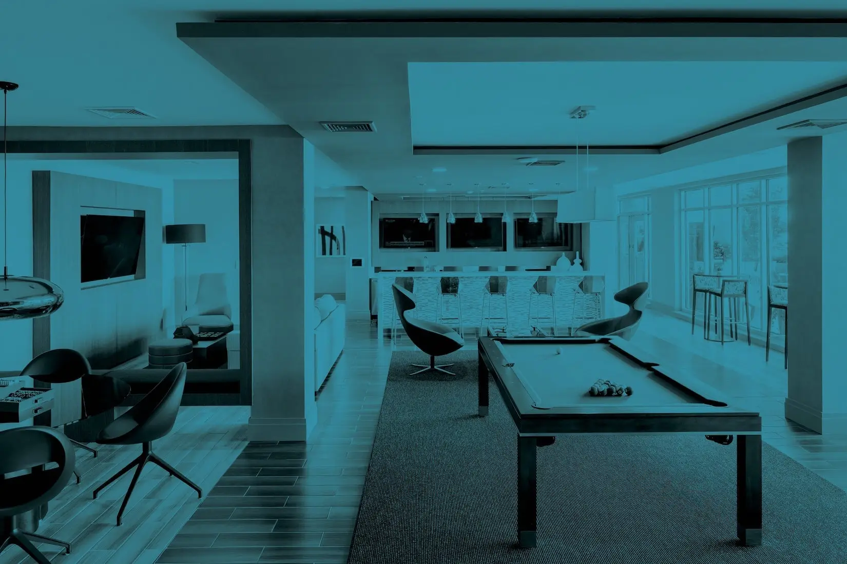 Ultra-modern open-plan living area with a billiards table, bar, and lounge seating under large windows.