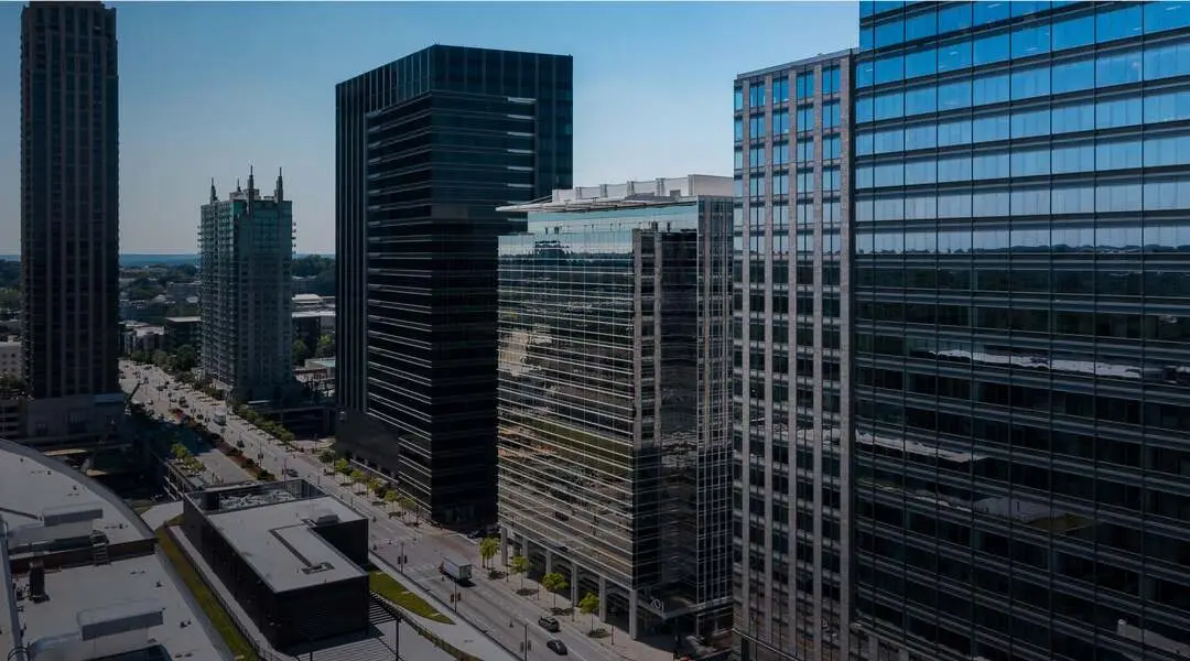 Modern skyscrapers stand along a city street. 201 is visible on one building.