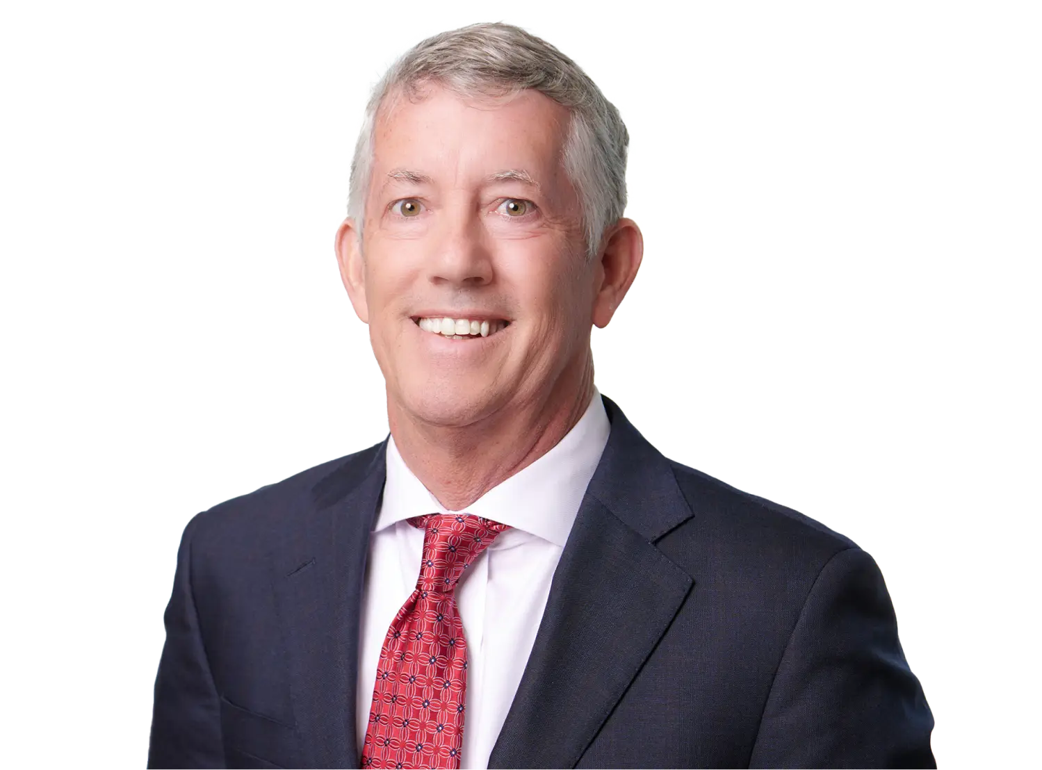 Smiling man in a navy suit, white shirt, and red patterned tie against a black background.